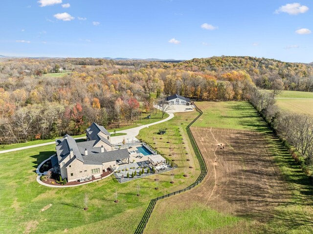 drone / aerial view featuring a wooded view and a rural view