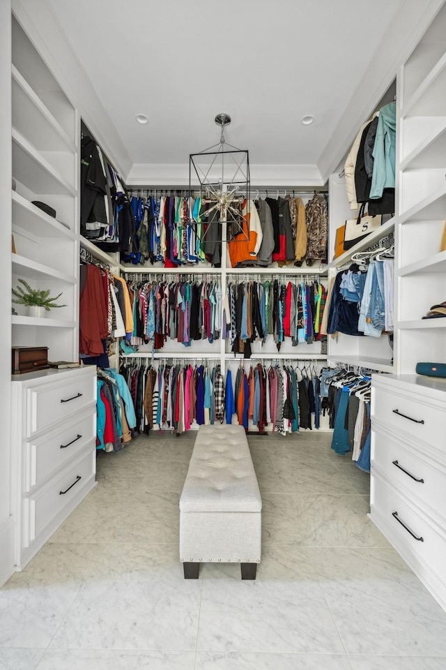 spacious closet featuring a chandelier