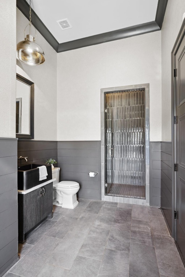 full bath with visible vents, wainscoting, toilet, vanity, and a shower stall