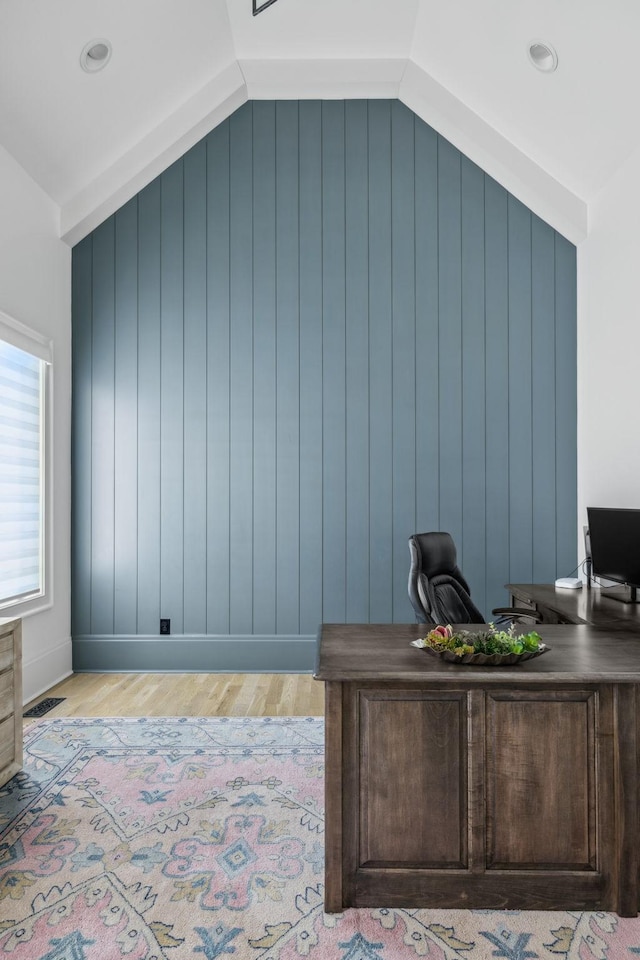 office space with light wood-style flooring, visible vents, and vaulted ceiling