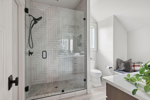 full bath featuring vaulted ceiling, a shower stall, toilet, and vanity