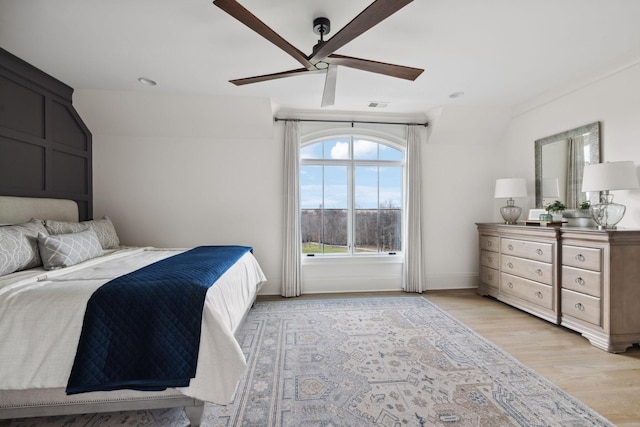 bedroom featuring light wood-type flooring, baseboards, visible vents, and a ceiling fan