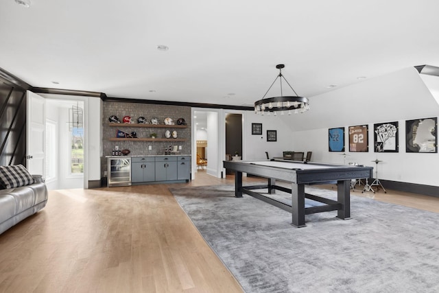 recreation room featuring vaulted ceiling, wine cooler, wood finished floors, and a dry bar