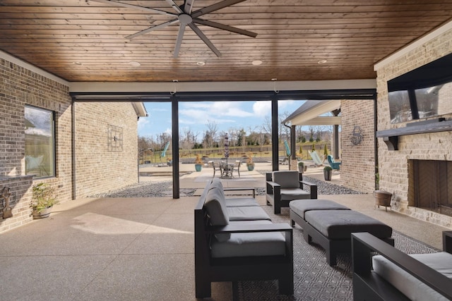 view of patio with a ceiling fan and an outdoor living space with a fireplace