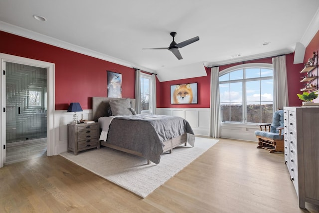 bedroom featuring ornamental molding, wainscoting, connected bathroom, ceiling fan, and wood finished floors