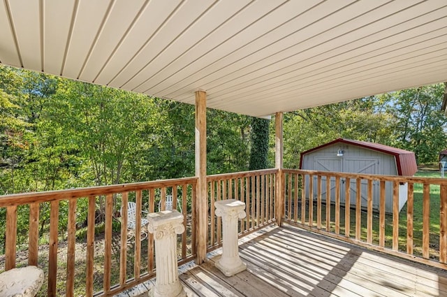 wooden deck with a storage shed and an outbuilding