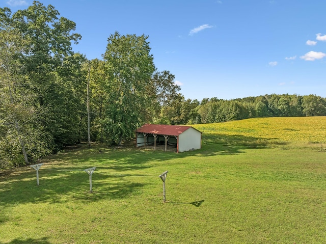 view of yard featuring an outbuilding and a forest view