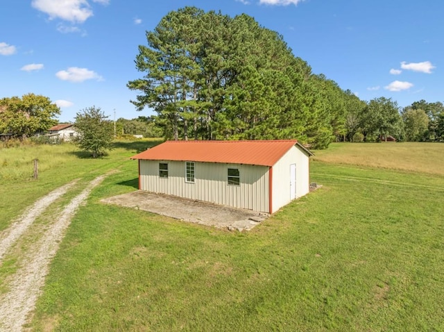 view of pole building with driveway and a lawn