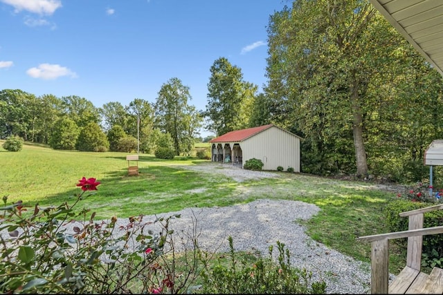 view of yard featuring driveway and an outbuilding