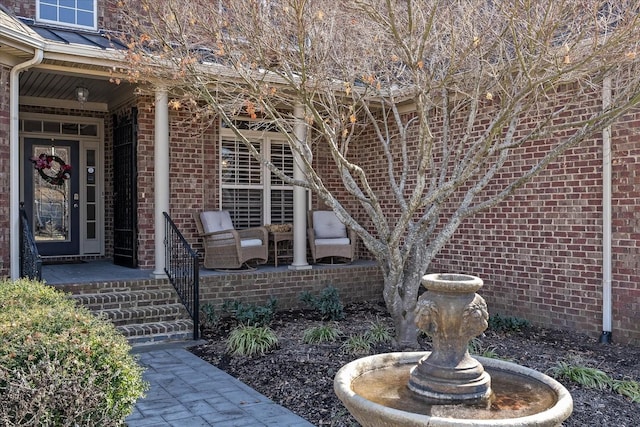 view of exterior entry with a standing seam roof, metal roof, and brick siding