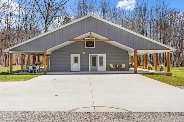 exterior space with a front yard, concrete driveway, and a patio