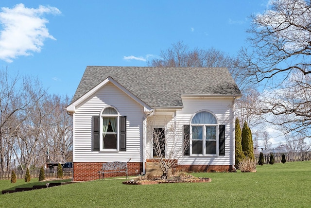 view of front of property featuring a shingled roof and a front lawn