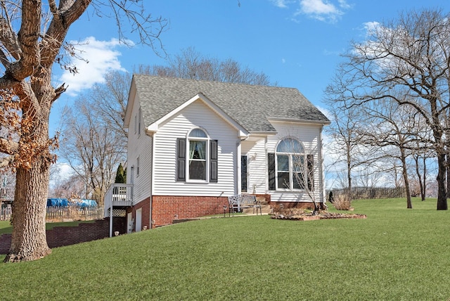 view of front of home featuring roof with shingles and a front lawn