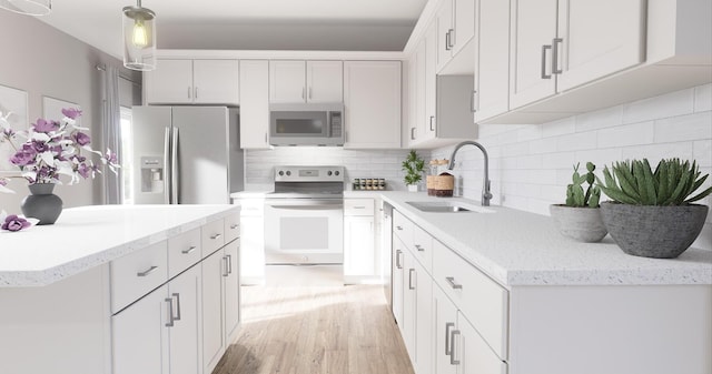 kitchen with stainless steel appliances, a sink, white cabinetry, light wood-type flooring, and backsplash