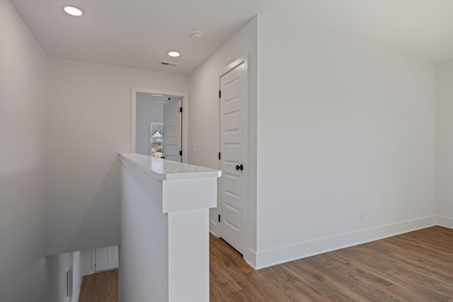 hallway featuring recessed lighting, visible vents, baseboards, and wood finished floors