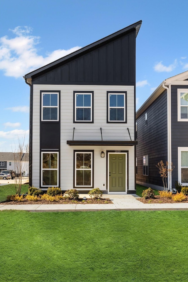 view of front of property featuring board and batten siding and a front yard