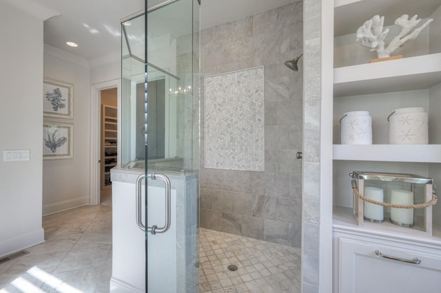 full bath featuring tile patterned flooring, visible vents, baseboards, a spacious closet, and a shower stall