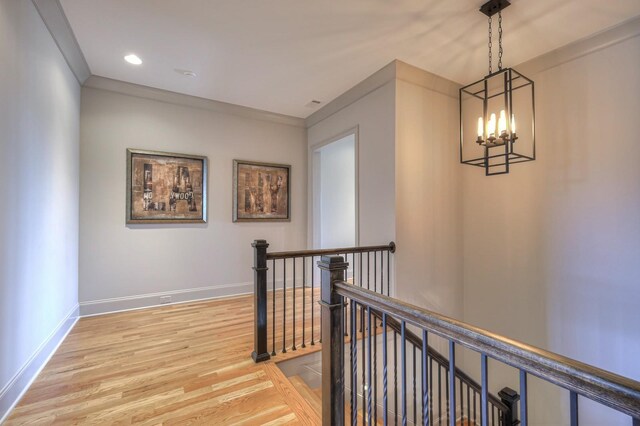 hallway featuring a notable chandelier, recessed lighting, an upstairs landing, baseboards, and light wood-type flooring