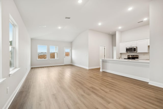 unfurnished living room featuring light wood-type flooring, baseboards, visible vents, and recessed lighting