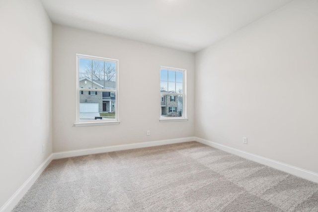 carpeted spare room featuring baseboards