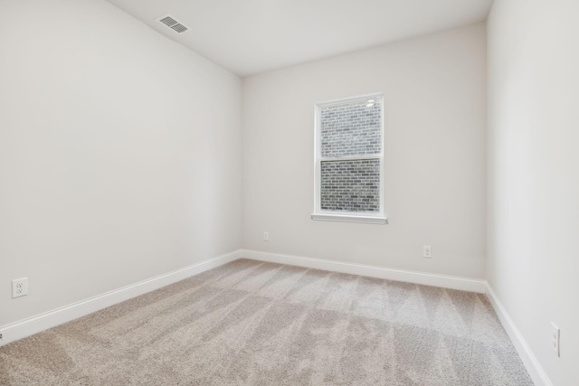 unfurnished room with light colored carpet, visible vents, and baseboards