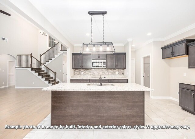 1163 Gardenia Ln, Clarksville, TN 37043 - kitchen with light stone counters, stainless steel microwave, dark brown cabinets, and a sink