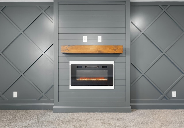 interior details with a glass covered fireplace and carpet flooring