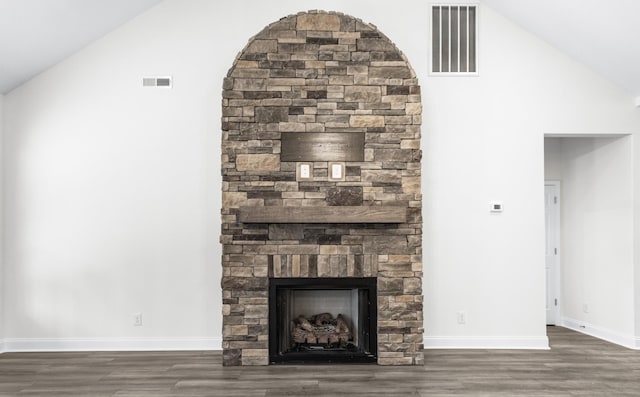 unfurnished living room featuring visible vents, a stone fireplace, baseboards, and wood finished floors