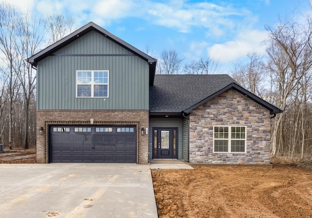 view of front of home featuring a shingled roof, driveway, board and batten siding, and an attached garage