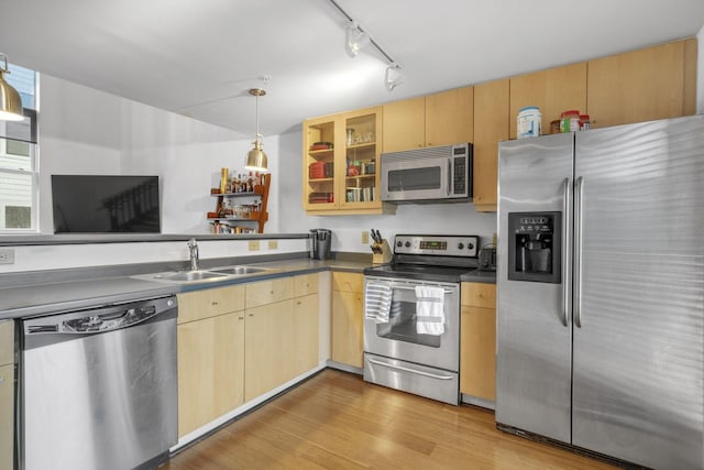 kitchen featuring light brown cabinetry, appliances with stainless steel finishes, a sink, and light wood-style flooring