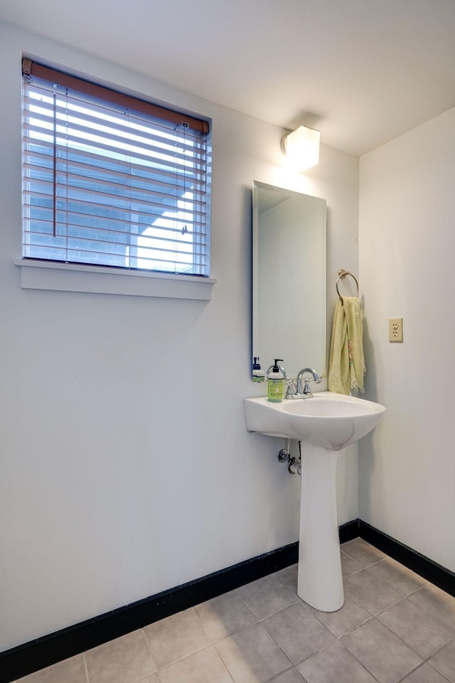 bathroom featuring tile patterned flooring, a sink, and baseboards