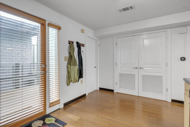 foyer entrance with visible vents and light wood-style floors