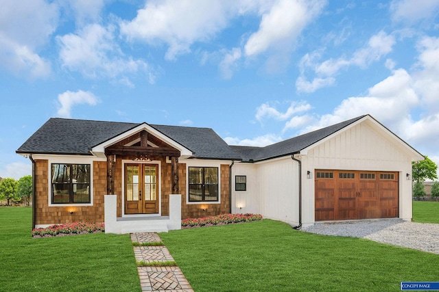 view of front facade with a garage, roof with shingles, and a front lawn