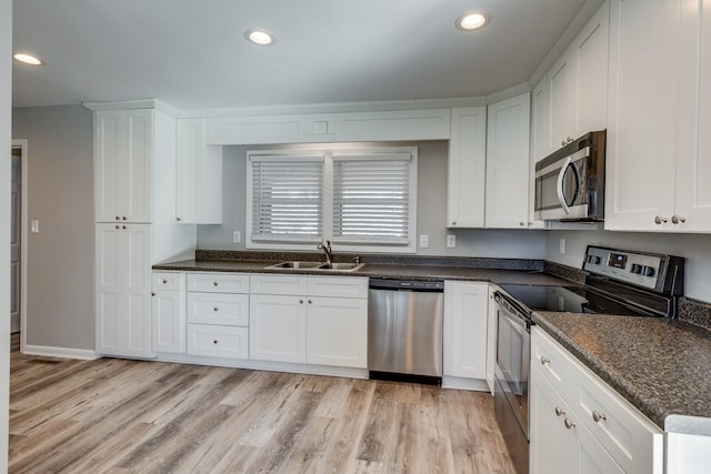 1311 Bel Aire Dr, Tullahoma, TN 37388 - kitchen featuring appliances with stainless steel finishes, a sink, white cabinetry, light wood finished floors, and recessed lighting