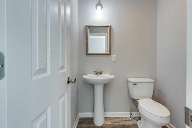 1311 Bel Aire Dr, Tullahoma, TN 37388 - half bath featuring toilet, wood finished floors, baseboards, and a sink