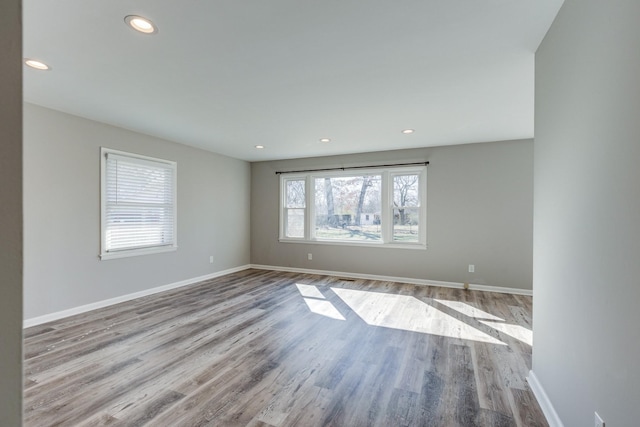 unfurnished room with recessed lighting, wood finished floors, and baseboards