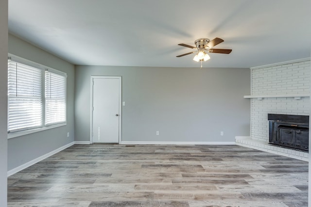 1311 Bel Aire Dr, Tullahoma, TN 37388 - unfurnished living room featuring a ceiling fan, wood finished floors, baseboards, and a brick fireplace