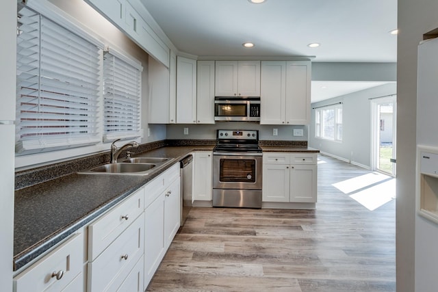 1311 Bel Aire Dr, Tullahoma, TN 37388 - kitchen featuring stainless steel appliances, a sink, light wood finished floors, recessed lighting, and white cabinets