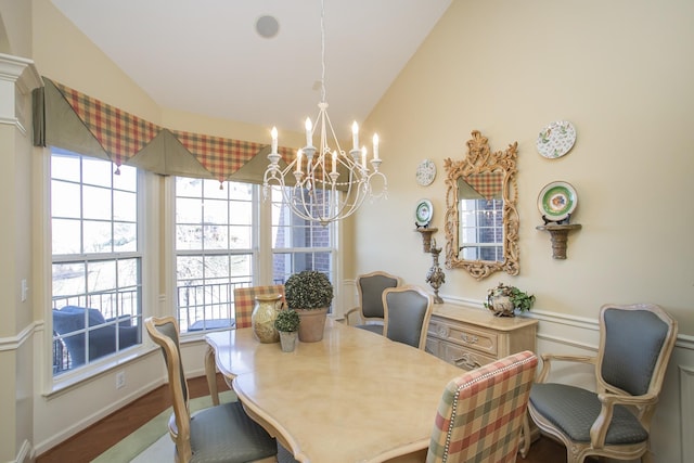 dining space with vaulted ceiling and a notable chandelier