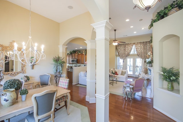 dining room featuring decorative columns, a high ceiling, a ceiling fan, and wood finished floors