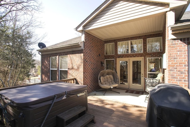 wooden terrace with area for grilling and a hot tub