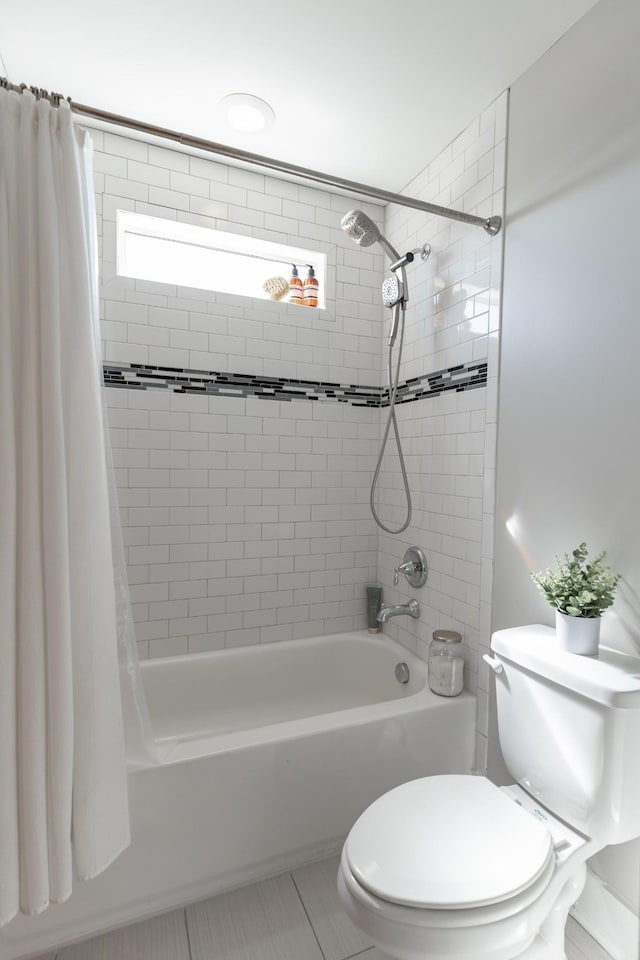 bathroom with tile patterned flooring, shower / bath combination with curtain, and toilet