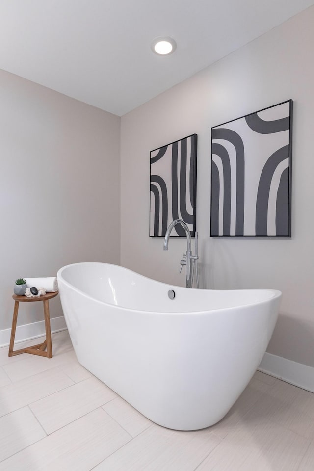 full bath with a freestanding tub and baseboards