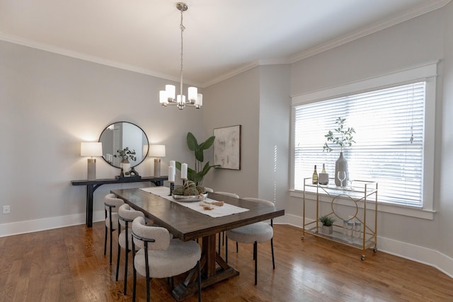 dining area with a notable chandelier, crown molding, baseboards, and wood finished floors