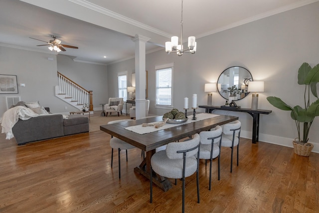 dining room featuring decorative columns, ornamental molding, wood finished floors, baseboards, and stairs