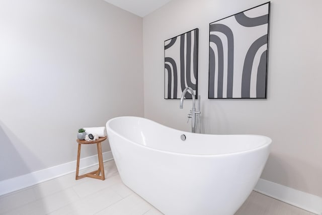 full bath featuring a soaking tub and baseboards