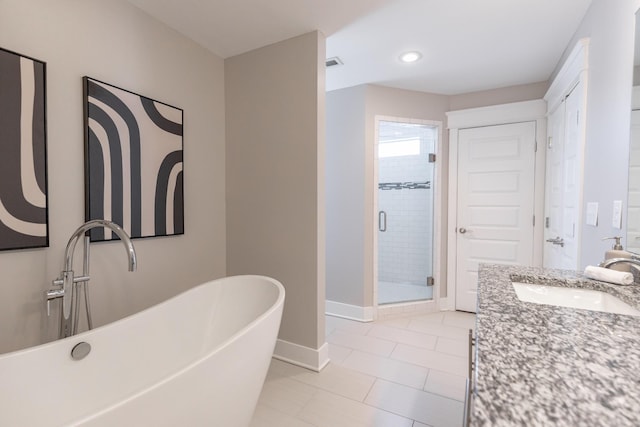 full bath with visible vents, vanity, baseboards, a soaking tub, and a stall shower