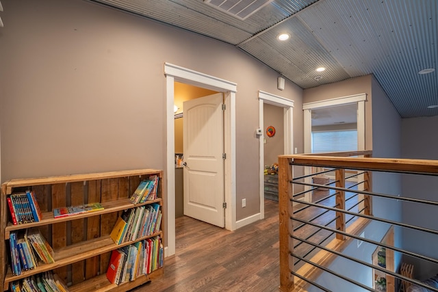 corridor featuring baseboards, wood finished floors, and recessed lighting