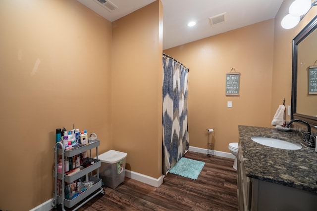 full bath featuring visible vents, vanity, baseboards, and wood finished floors