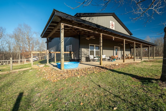 back of property featuring ceiling fan, a patio, a yard, and fence